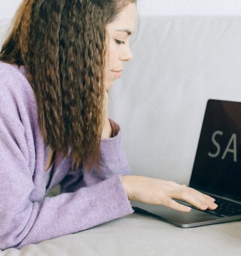 Laptop Deals - A Woman Using Her Laptop while Lying on a Sofa