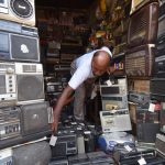 Electronics Store - Man in a Room with Vintage Radios