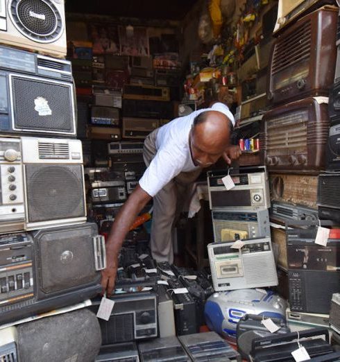 Electronics Store - Man in a Room with Vintage Radios