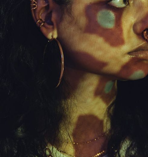 Projectors - A Woman Wearing White Shirt and Jewelries in Front of the Projector Light