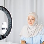 Home Décor Brands - Woman in a Hijab Taking Video of Herself with Phone and Ring Light