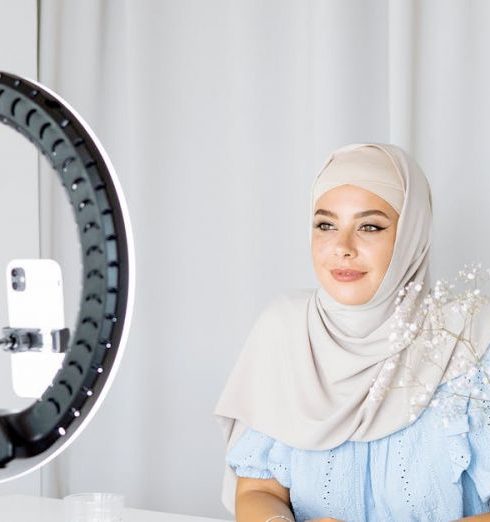 Home Décor Brands - Woman in a Hijab Taking Video of Herself with Phone and Ring Light