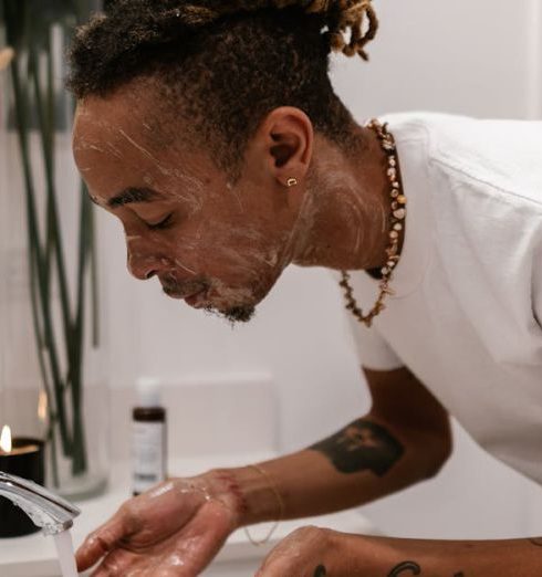 Organic Products - Man with Dreadlocks Washing his Face at Sink