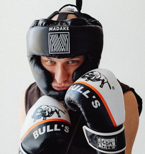 Fitness Equipment Brands - Man in Black Muscle Shirt Wearing Black Headgear and Boxing Gloves