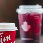 Canadian Brands - Disposable Coffee Cup from Tim Hortons Chain Restaurant Next to a Donut and a Cup of Cold Drink