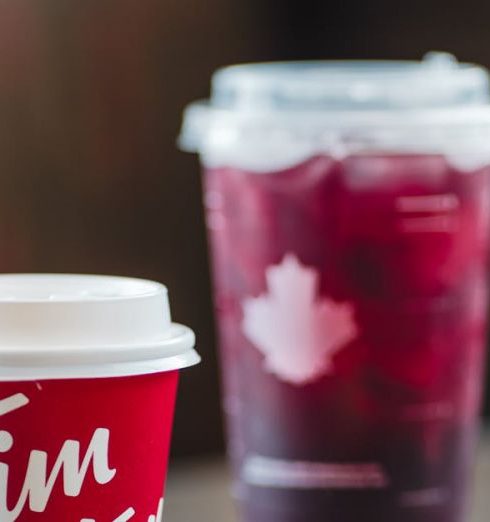 Canadian Brands - Disposable Coffee Cup from Tim Hortons Chain Restaurant Next to a Donut and a Cup of Cold Drink