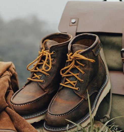 Outdoor Equipment - A Jacket, Boots and a Backpack Lying on the Ground