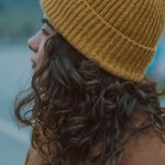 Outdoor Apparel - Young Woman in a Brown Coat and Yellow Hat Standing Outside