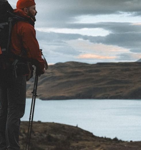 Trekking Poles - Man Standing on Hill with Backpack