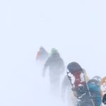 Snowshoeing Gear - Snowboarders Walking in Snowstorm