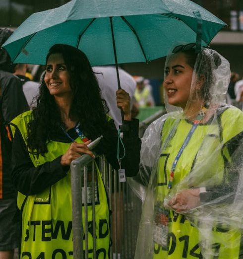 Rain Gear - Smiling Stewards at Stadium in Rain