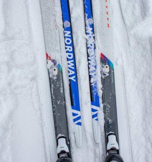 Cross-Country Ski Gear - A Person Wearing Snow Skis on Snow Covered Ground