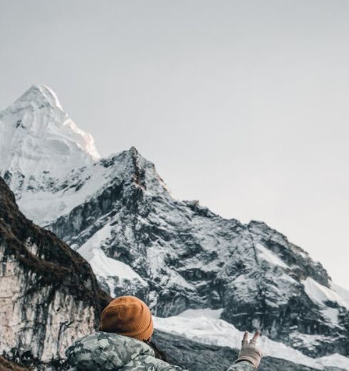 Hiking Gear - Hiker Posing on Trail with Snowcapped Mountain in Background