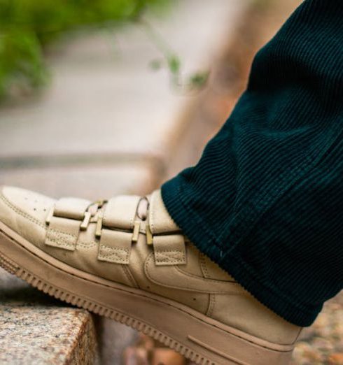 Outdoor Footwear - A Person in Black Pants Wearing White Sneakers