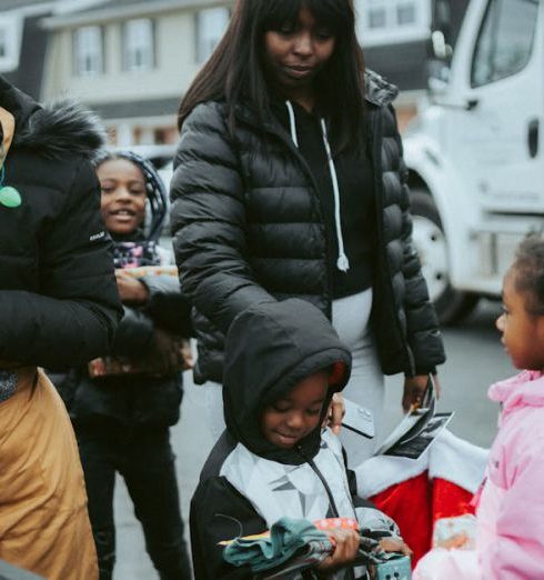 Outdoor Gifts - Volunteer Giving Presents to Children on a Christmas Event in City