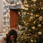 New Parent Gifts - A Child Sitting next to a Christmas Tree with his Mom