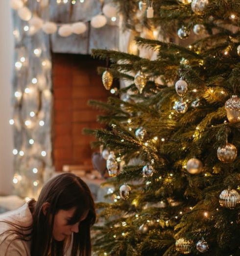 New Parent Gifts - A Child Sitting next to a Christmas Tree with his Mom