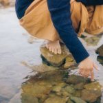 Kids' Clothing - Child Squatting and Playing in Water