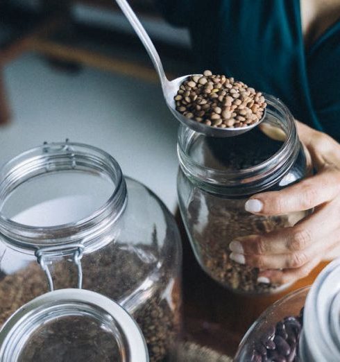 Home Goods - A Person Refilling Beans on a Glass Jar