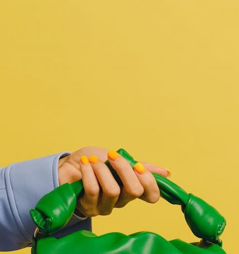 Luxury Handbag - A Person Holding a Green Handbag