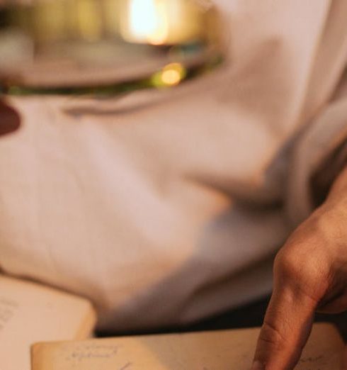 Rare Books - A Person Holding a Magnifying Glass and a Paper