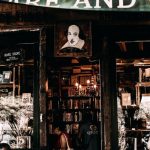 Local Bookshops - Multiethnic people near entrance of old shop with glass cases in city at daytime