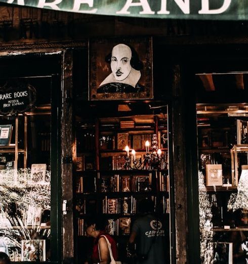 Local Bookshops - Multiethnic people near entrance of old shop with glass cases in city at daytime