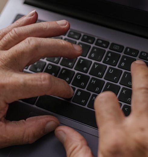 Home Office Gadgets - Elderly Person Typing on Keyboard