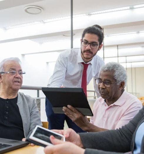 Seniors Gadgets - A Man Teaching Elderly People About Computers