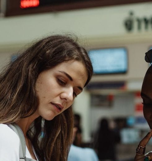 Travel Gadgets - Women Using a Smartphone on a Train Station