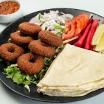 International Foods - Onion Rings with Vegetables and Bread on Black Plate