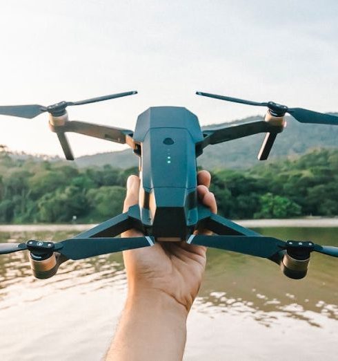 Photography Gadgets - Man Holding Drone over River