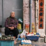 Vintage Markets - Woman Sitting and Selling Food on a Street Corner