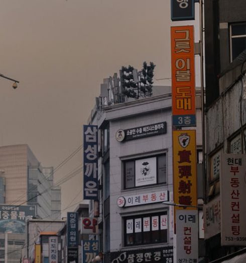 Pop-Up Shops - Street Among Buildings in Shadow