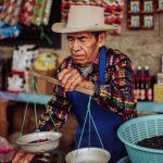 Shopping Experiences - Merchant Working at Market Stall