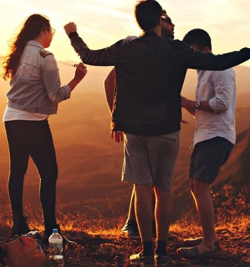 Teens - Four Person Standing at Top of Grassy Mountain