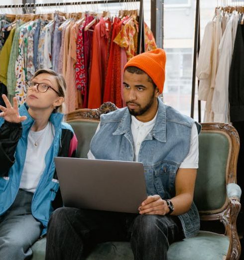 Diverse Retail - A Man and a Woman Using a Laptop while Sitting on a Couch