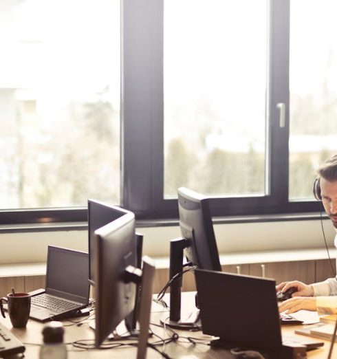 Customer Service - Man With Headphones Facing Computer Monitor