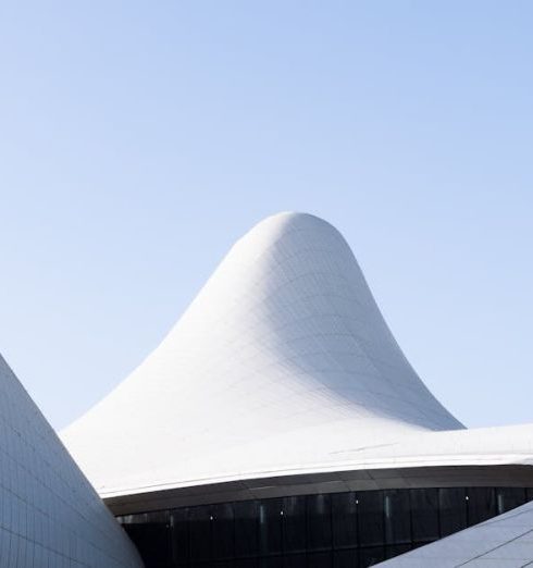 Unique Attractions - Person Riding Bicycle in Front of the Heydar Aliyev Centre