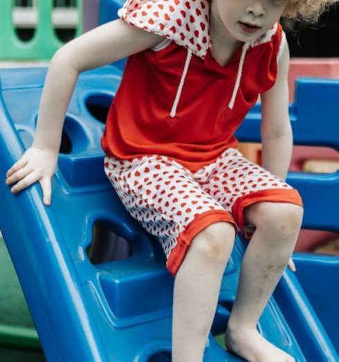 Kids Activities - Blonde Boy in Red T-Shirt Playing on Slide