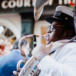 Live Entertainment - Man in White Shirt and a Cap Playing the Tuba on a Street