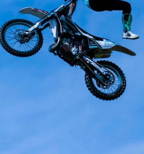 Outdoor Adventure Gear - Photo of a Man Jumping a Motorbike Midair