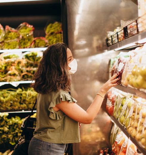 Supermarkets - Woman Browsing through Groceries on a Shelf in a Supermarket