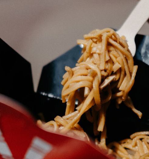 Food Markets - Hands Holding Fork and Noodles in Box