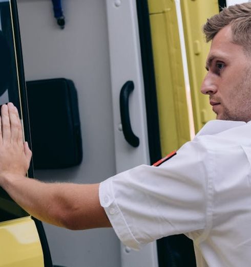 Response Time - Emergency medical technician securing ambulance door, focusing on readiness.