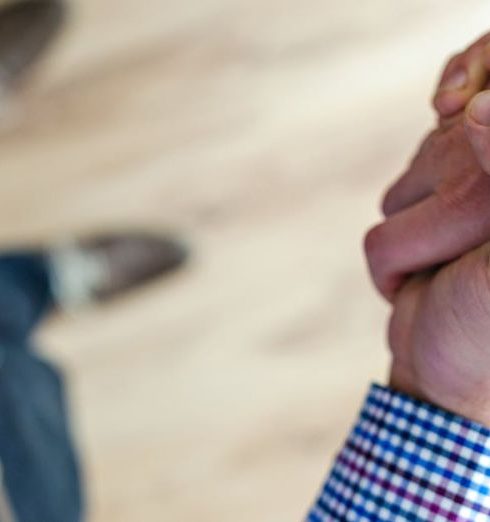 Trust - Close-up of a handshake between two people inside an office, symbolizing trust and cooperation.