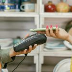 Mobile Commerce - A customer makes a cashless payment using a smartphone in a retail store. Modern technology meets convenience.