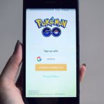 Augmented Reality - Smartphone displaying Pokémon Go app sign-in screen, held in hand.