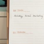 Email Marketing - Planner open on a desk with handwritten 'Holiday Email Marketing Series' note.