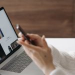 Product Page - Asian woman shopping online with a laptop and smartphone at home.